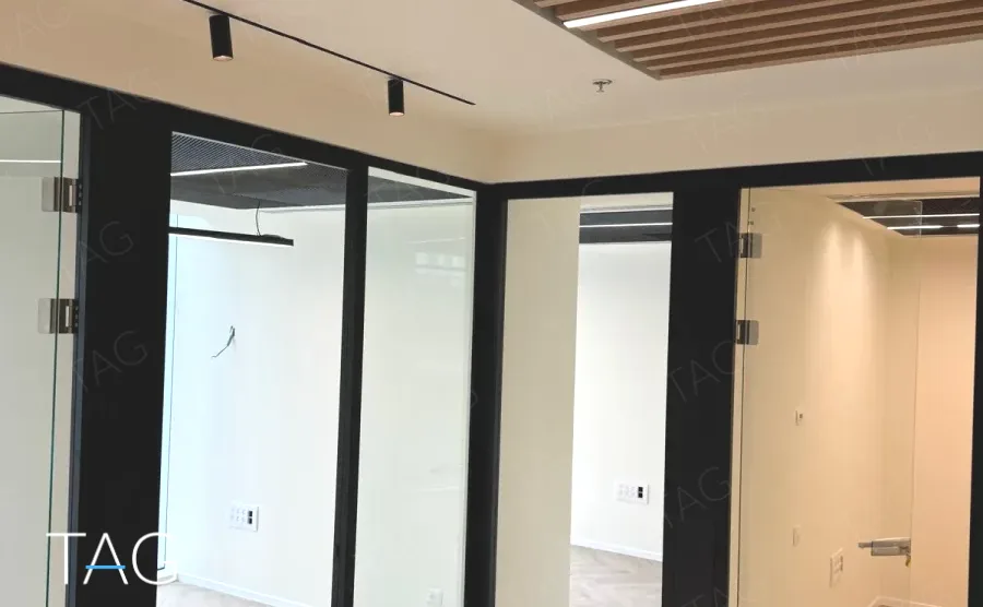מסדרון משרדים בACRO BUSINESS CAMPUS עם מחיצות זכוכית ותקרת סנפירי עץ - תג נכסים