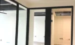 חדרי משרד מזוגגים בACRO BUSINESS CAMPUS עם מסגרות שחורות ומיזוג מיני מרכזי - תג נכסים
