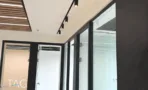 אזור משרדי בACRO BUSINESS CAMPUS עם תקרת סנפירים, מחיצות זכוכית ותאורת פסים - תג נכסים