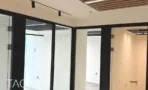 חלל משרדי בACRO BUSINESS CAMPUS עם תקרת עץ מחורצת ומחיצות זכוכית שחורות - תג נכסים