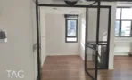 מעבר פנימי במשרד להשכרה בשדרות רוטשילד תל אביב - דלתות זכוכית במסגרת שחורה ורצפת פרקט - תג נכסים