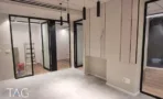 חלל משרדי בACRO BUSINESS CAMPUS עם חיפוי קיר מחורץ, מחיצות זכוכית ותאורה תלויה - תג נכסים