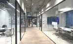 מסדרון בין חדרי זכוכית עם מסגרות שחורות במשרד 347 מ״ר במגדל אקרו