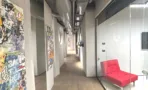 מסדרון עם קיר אמנות רחוב וספת אורח אדומה במשרד 347 מ״ר במגדל אקרו
