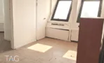 פינת חלונות משופעים ואור שמש על רצפת פרקט במשרד בבית הטקסטיל - תג נכסים