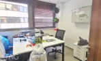חדר עבודה במשרד להשכרה בבית לב מונטיפיורי תל אביב, עמדות עבודה לבנות מול חלון עם תריס עץ