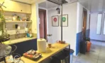 מטבחון במשרד להשכרה בבית לב מונטיפיורי תל אביב, ארונות עץ בהיר, כיור ושולחן בר ארוך