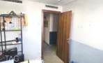 מסדרון פנימי במשרד להשכרה בבית לב תל אביב, דלת עץ חומה, כוננית מתכת ורצפת אריחים בהירה