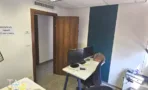 חדר עבודה במשרד להשכרה בבית לב תל אביב, קיר מודגש בכחול כהה, עמדת מחשב כפולה ודלת עץ