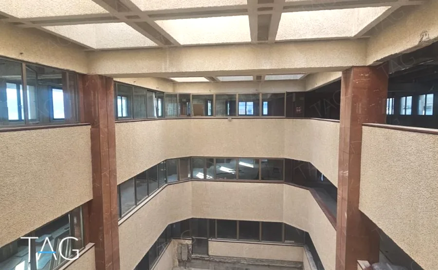חצר פנימית מקורה בתקרת בטון משובצת, ומעליה שורות חלונות בשתי קומות, במשרד 3,000 מ