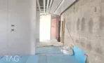 קיר בטון חשוף וצנרת גלויה בתקרה בזמן עבודות, במשרד 300 מ