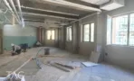 עבודות גמר בחלל פתוח עם קיר בגוון ירוק ורצפת טרצו, במשרד 300 מ