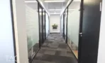 מסדרון משרד עם קיר לוח מחיק ודלתות שחורות במגדל רוטשילד 22