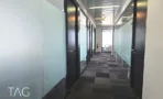 מסדרון עם מחיצות זכוכית חלבית ושטיח משבצות במגדל רוטשילד 22