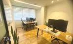 חלל עבודה משותף במשרד להשכרה ברחוב הוברמן תל אביב, שולחנות עץ, מסכים וצמחייה - תג נכסים
