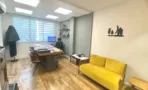 חדר עבודה במשרד להשכרה ברחוב הוברמן תל אביב, ספה צהובה, שולחן עבודה ורצפת פרקט - תג נכסים