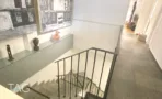 מבט אל גרם המדרגות שמחבר בין שני מפלסי המשרד להשכרה ברחוב הוברמן תל אביב, מעקה מתכת ומחיצת זכוכית - תג נכסים