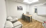 חדר עבודה עם פינת ישיבה במשרד להשכרה ברחוב הוברמן תל אביב, כורסאות אפורות ולוח מחיק - תג נכסים