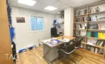 חדר עבודה עם ספרייה במשרד להשכרה ברחוב הוברמן תל אביב, מדפים מלאי קלסרים ושולחן עץ - תג נכסים