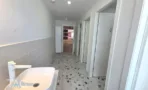 שירותים במשרד להשכרה ברחוב ליאונרדו דה וינצ'י תל אביב, כיור לבן, אריחים בהירים ורצפת טראצו צבעונית - תג נכסים