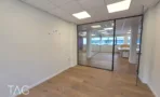 מבט מחדר פינתי אל החלל הפתוח במשרד להשכרה ברחוב ליאונרדו דה וינצ'י תל אביב, מחיצת זכוכית וחלונות רחבים - תג נכסים