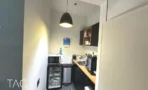 מטבחון קטן עם מנורת תליה שחורה ומשטח עץ