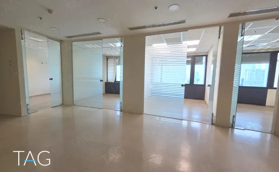 חלל עם מחיצות זכוכית ורצפת אבן בהירה מול רצועת חלונות במשרד להשכרה 423 מ