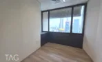 חדר ריק עם חלון פינתי וארון בנוי כהה מתחתיו במשרד להשכרה 423 מ