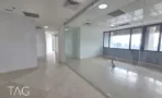 מסדרון פנימי שמוביל לחלל מזוגג עם רצפת אבן בהירה במשרד להשכרה 527 מ