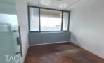 חדר ריק עם חלון רחב, ארון בנוי אפור ורצפת פרקט כהה במשרד להשכרה 527 מ