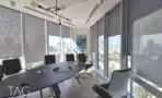 משרד להשכרה 260 מ״ר במגדל WE, חדר ישיבות עם שולחן אובלי מול חלונות פנורמיים לנוף העיר