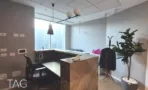 משרד להשכרה 260 מ״ר במגדל WE, עמדת קבלה מעץ עם תאורה תלויה ועציץ