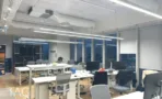 משרד להשכרה 450 מ״ר במגדל WE, חלל עבודה פתוח עם עמדות מחשב מול חלונות פנורמיים