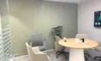 משרד להשכרה 450 מ״ר במגדל WE, חדר ישיבות עם שולחן עגול ומסך על הקיר