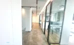 משרד להשכרה 220 מ״ר במגדלי אלון, מסדרון עם חדרי זכוכית ועמדות עבודה