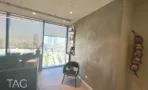 חדר עבודה עם נוף פנורמי של תל אביב וקיר בטון מוחלק
