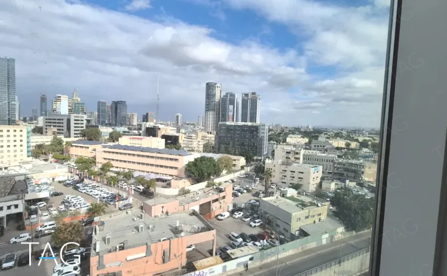 נוף מהחלון על גגות השכונה ומגדלי המרכז ממשרד 170 מ