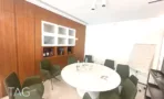 משרד להשכרה 200 מ״ר במגדלי אלון, חדר ישיבות עם שולחן שיש עגול, כיסאות ירוקים ולוח כתיבה