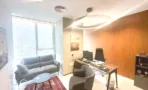 משרד להשכרה 200 מ״ר במגדלי אלון, חדר מנהל עם ספה, שולחן זכוכית וגוף תאורה עגול