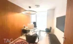משרד להשכרה 200 מ״ר במגדלי אלון, חדר עבודה עם קיר עץ, שולחן מחשב ומסך על הקיר