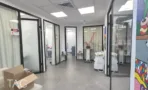 משרד להשכרה 185 מ״ר במגדלי אלון, מסדרון עם חדרי טיפולים בדלתות זכוכית וציוד מקצועי