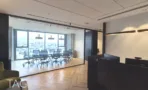 משרד להשכרה 242 מ״ר במגדלי אלון, אזור קבלה עם דלפק כהה וחדר ישיבות מזוגג ברקע