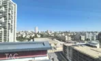 משרד להשכרה 360 מ״ר במגדלי אלון, נוף עירוני פתוח מהחלון עם מגדלי מגורים ושמיים כחולים