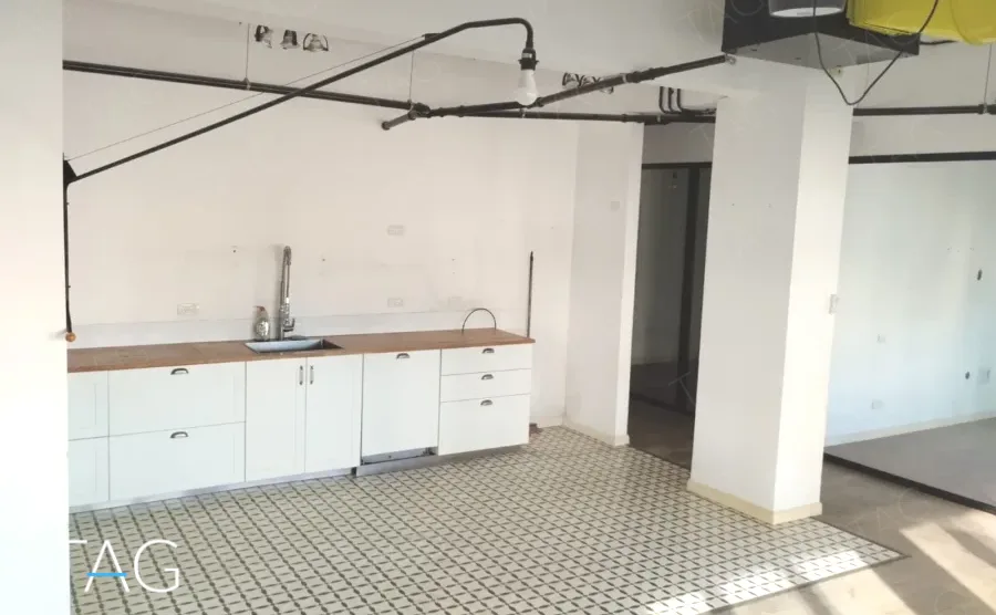 מטבחון לבן עם משטח עץ ואריחי מלט מצוירים במשרד להשכרה במתחם רוטשילד תל אביב - תג נכסים