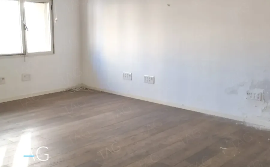 חדר ריק עם רצפת עץ רחבה וחלון פינתי במשרד להשכרה במתחם רוטשילד תל אביב - תג נכסים