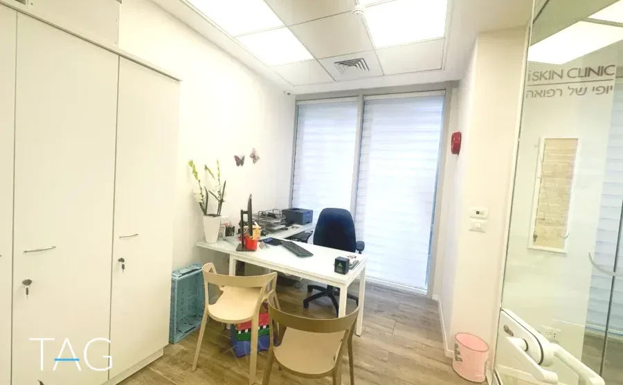 משרד להשכרה 128 מ״ר במגדל WE, חדר טיפולים עם שולחן עבודה וארונות לבנים