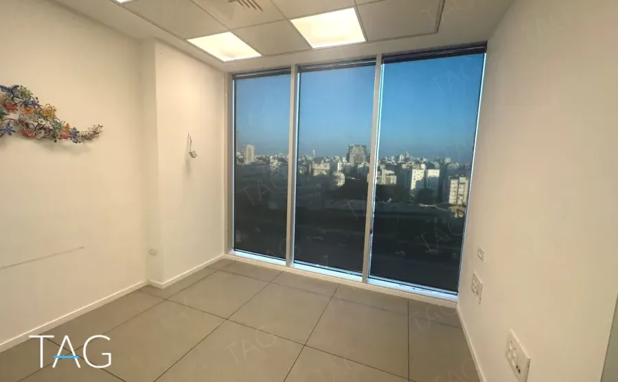 משרד להשכרה 100 מ״ר במגדל WE, חדר ריק עם חלונות גדולים לנוף העיר