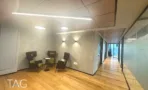 משרד להשכרה 280 מ״ר במגדל WE, פינת המתנה עם כורסאות ופרקט לאורך המסדרון