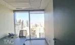 חדר עבודה עם שולחן וקיר כהה מול חלון פינתי