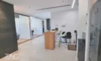 פינת מטבח עם רצפת אריחים בהירה, משטח עץ וכיסאות בר